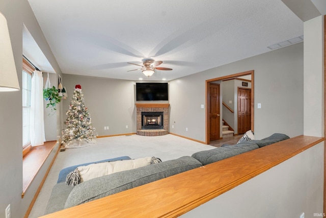 living room with ceiling fan, light carpet, and a brick fireplace