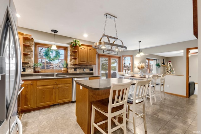 kitchen featuring sink, a kitchen bar, stainless steel appliances, tasteful backsplash, and a kitchen island