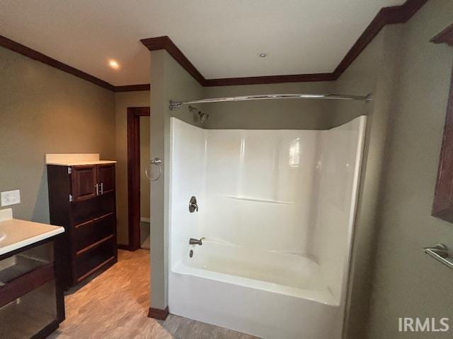 bathroom featuring washtub / shower combination, ornamental molding, and vanity