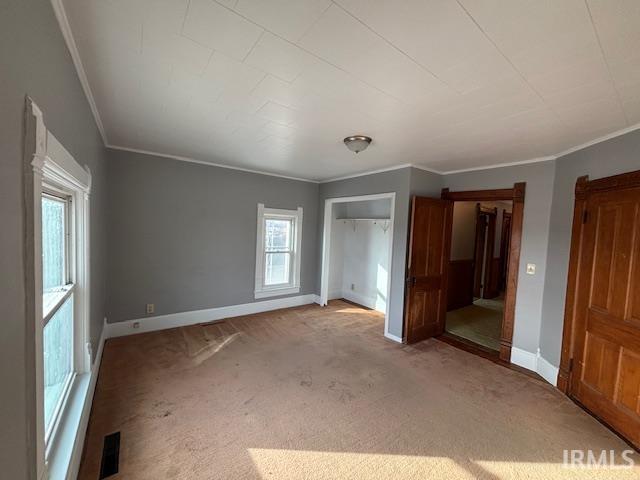 unfurnished bedroom with crown molding and carpet flooring