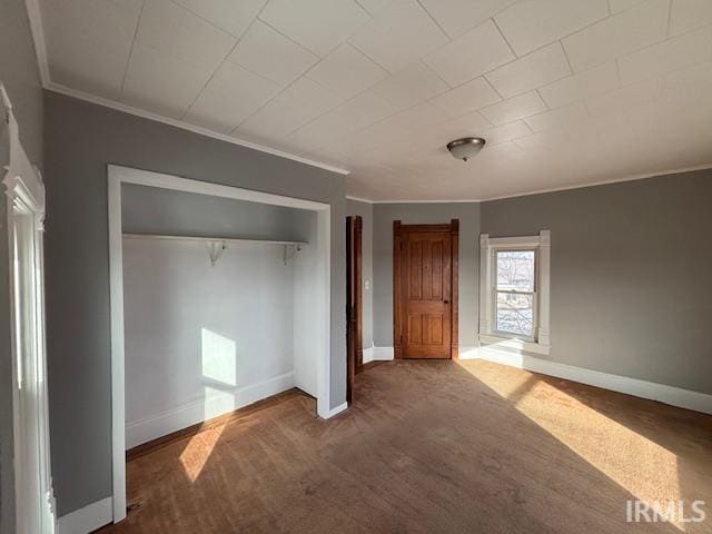 unfurnished bedroom featuring ornamental molding, a closet, and carpet