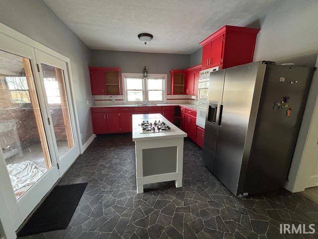 kitchen with appliances with stainless steel finishes, sink, and a textured ceiling