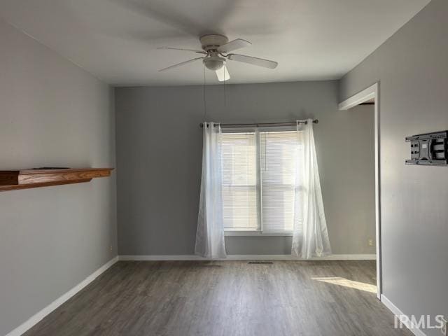 unfurnished room featuring dark hardwood / wood-style floors and ceiling fan