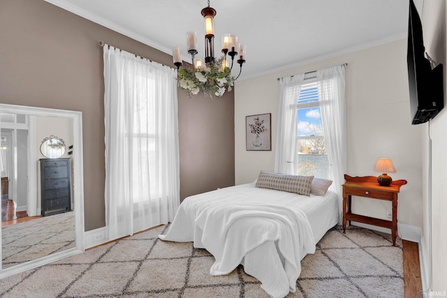 bedroom with a notable chandelier, crown molding, and light hardwood / wood-style floors