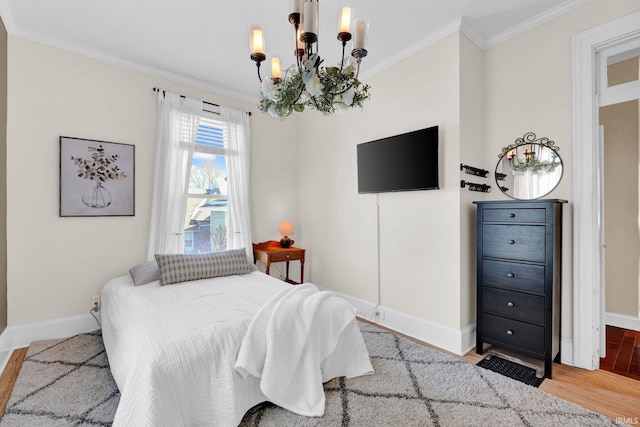 bedroom featuring ornamental molding, an inviting chandelier, wood finished floors, and baseboards