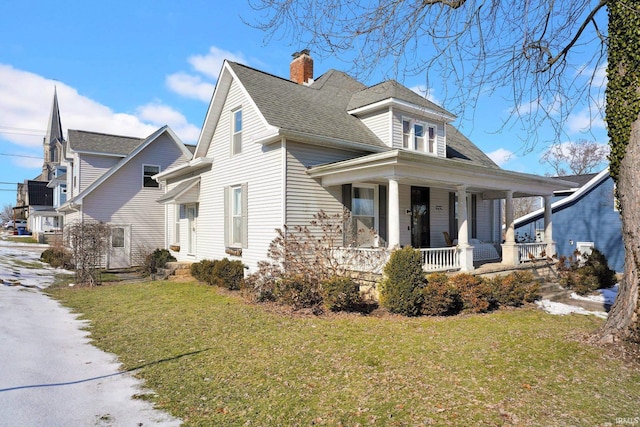 view of side of home with roof with shingles, a chimney, a porch, and a yard