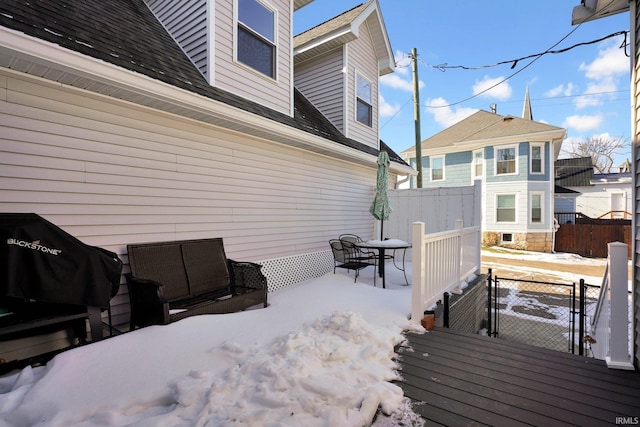 snow covered deck with a gate and fence