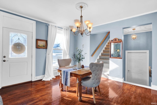 dining space with crown molding, baseboards, wood finished floors, and an inviting chandelier