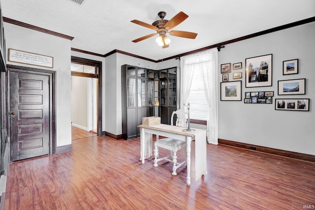 home office featuring crown molding, wood-type flooring, and ceiling fan