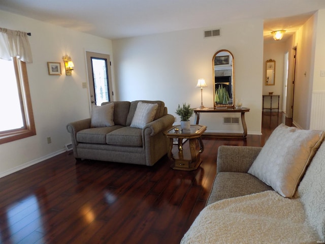 living room featuring dark wood-type flooring and plenty of natural light