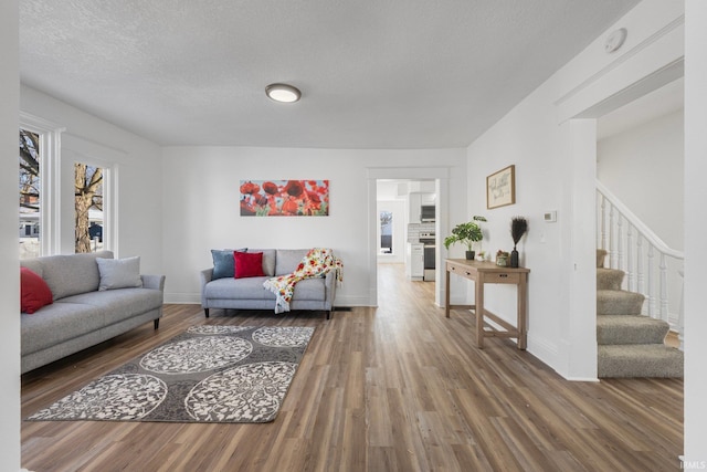 living room featuring wood-type flooring and a textured ceiling