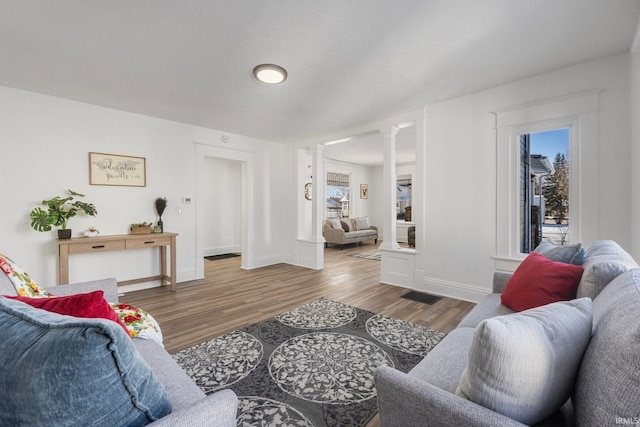 living room featuring hardwood / wood-style flooring and ornate columns