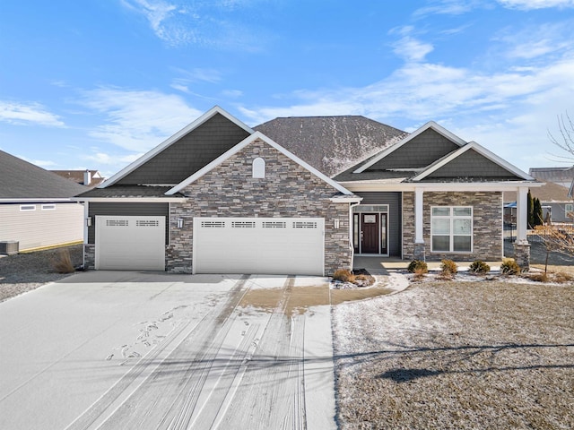 craftsman-style home featuring cooling unit and a garage