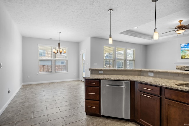 kitchen with dishwasher, decorative light fixtures, light stone counters, and a tray ceiling