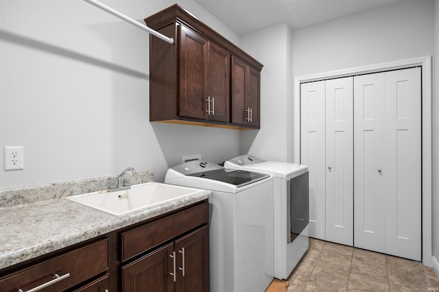 laundry area with separate washer and dryer, sink, and cabinets