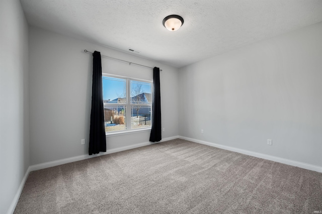 carpeted spare room with a textured ceiling