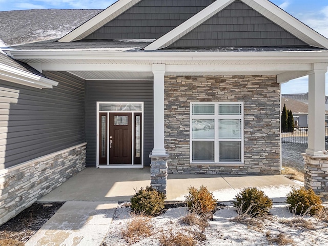 snow covered property entrance featuring a porch