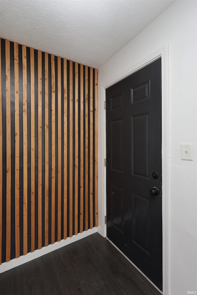 entryway featuring dark wood-type flooring and a textured ceiling