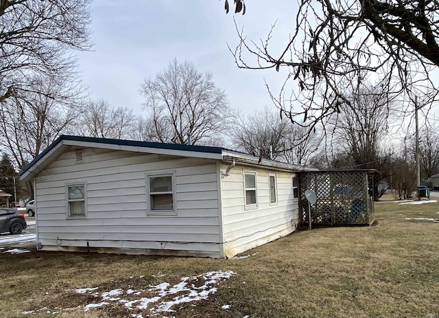 view of side of home with a yard