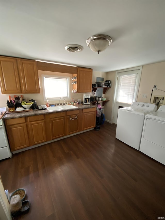 kitchen featuring sink, washing machine and dryer, dark hardwood / wood-style floors, and range