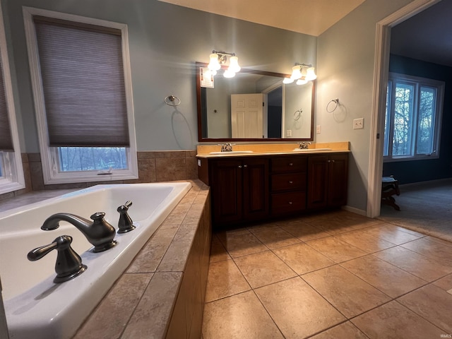 bathroom with vanity, tiled tub, and tile patterned flooring