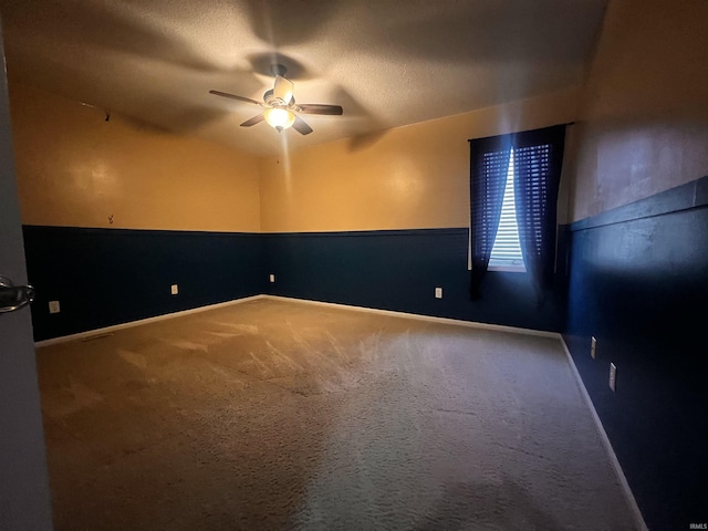 unfurnished room with ceiling fan, a textured ceiling, and carpet