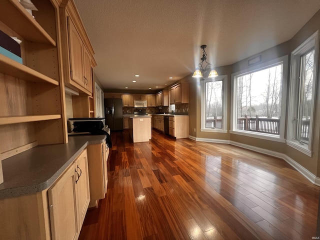 kitchen featuring a kitchen island, pendant lighting, dark hardwood / wood-style flooring, black appliances, and light brown cabinets