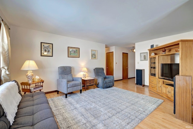 living room featuring an inviting chandelier and light hardwood / wood-style flooring