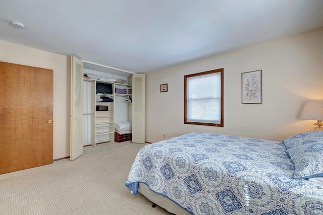 bedroom with a closet and light carpet