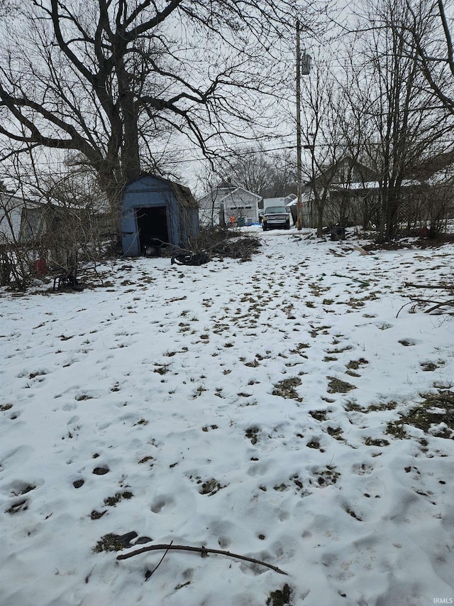 yard layered in snow with a shed