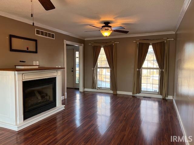 unfurnished living room featuring ceiling fan, ornamental molding, and dark hardwood / wood-style floors