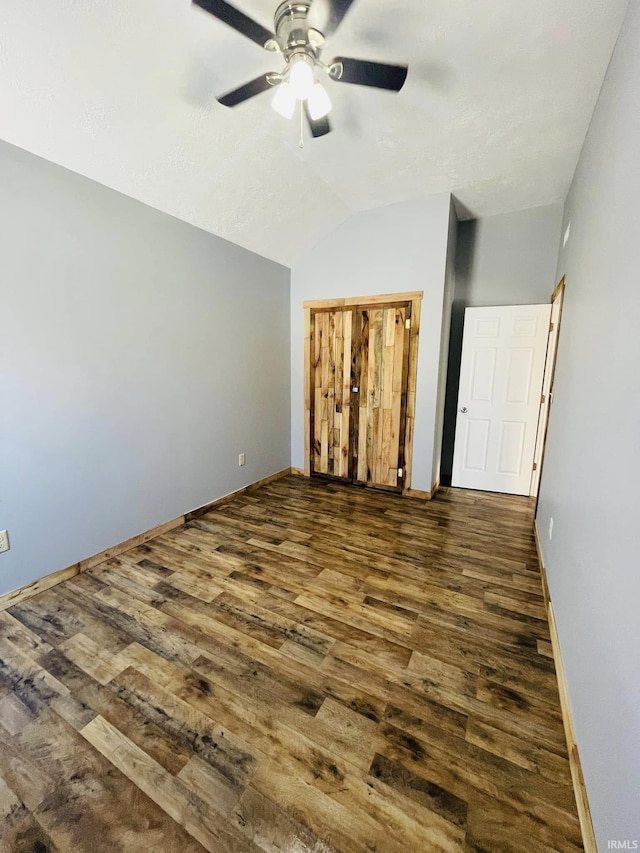 interior space featuring lofted ceiling, dark wood-type flooring, and ceiling fan