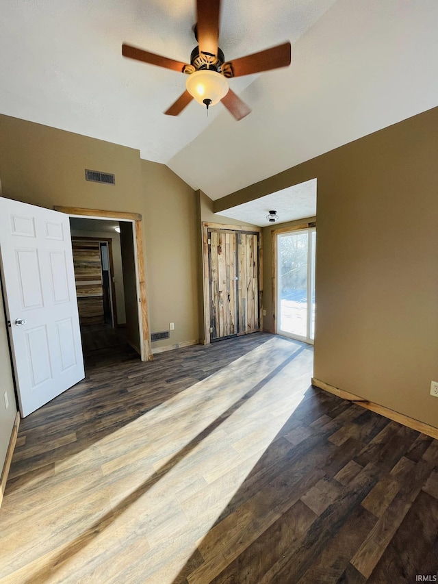 empty room with ceiling fan, lofted ceiling, and dark hardwood / wood-style floors