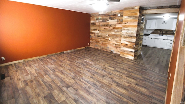 empty room with dark wood-type flooring, sink, and ceiling fan