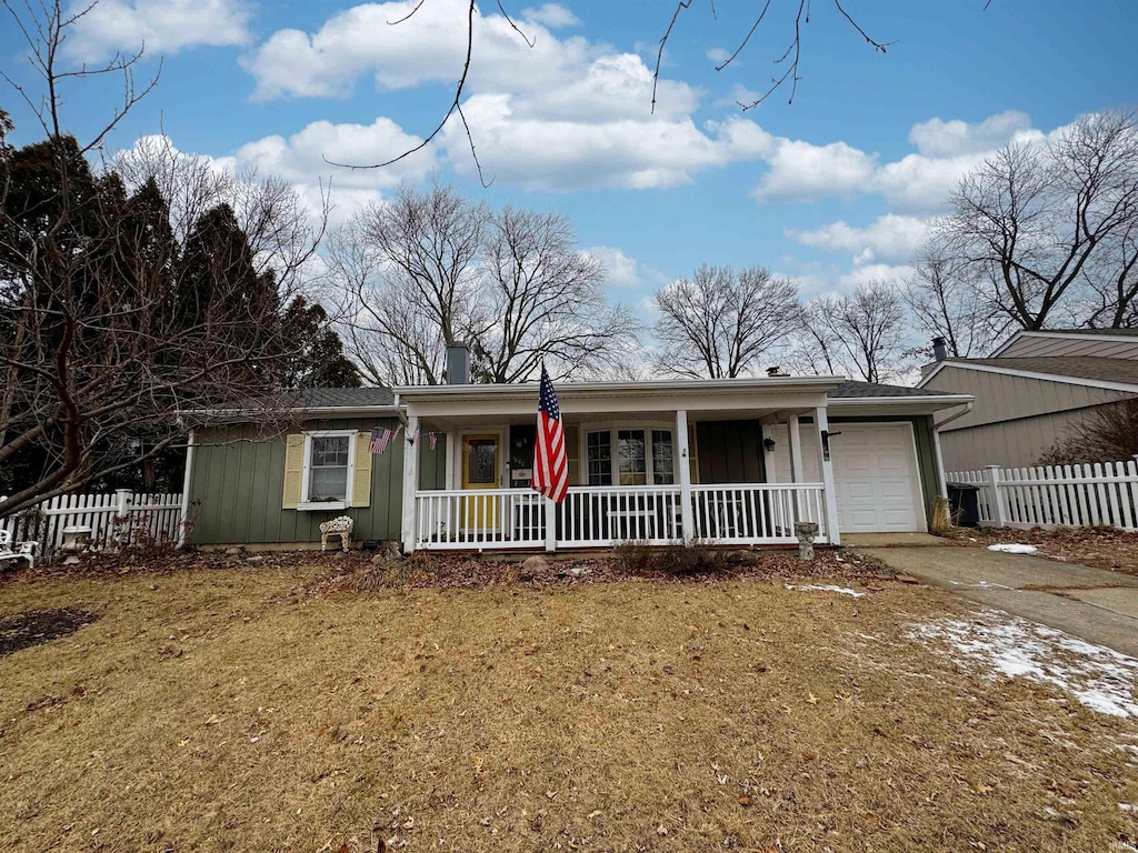 single story home featuring a porch, a garage, and a front lawn