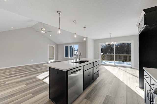 kitchen with decorative light fixtures, sink, a kitchen island with sink, stainless steel dishwasher, and light hardwood / wood-style floors