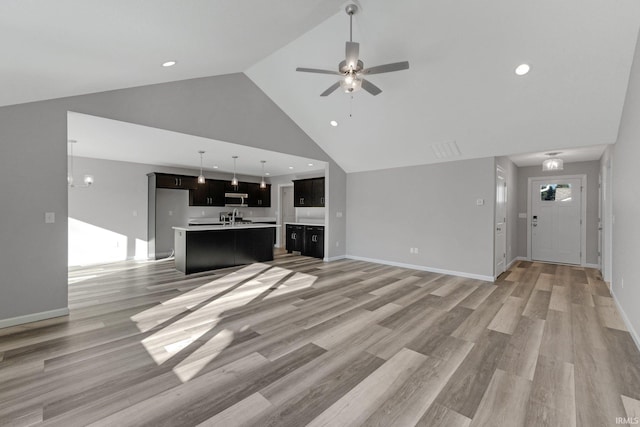 unfurnished living room with ceiling fan, high vaulted ceiling, and light hardwood / wood-style floors