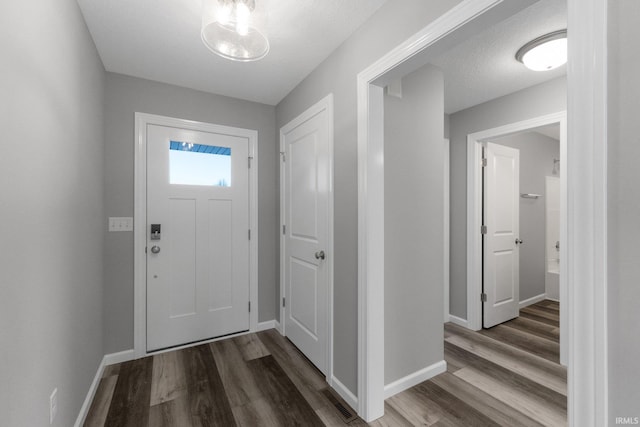 foyer featuring wood-type flooring and a textured ceiling