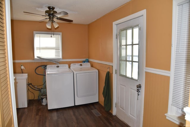 washroom with ceiling fan, dark hardwood / wood-style floors, washing machine and clothes dryer, a textured ceiling, and wood walls