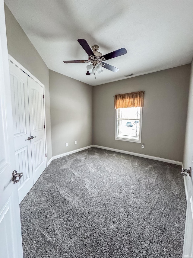 unfurnished room with ceiling fan and carpet flooring