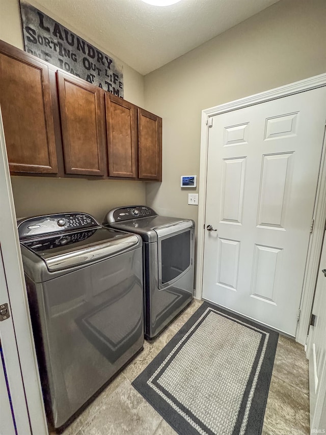 washroom with cabinets and washing machine and clothes dryer