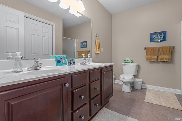 bathroom featuring tile patterned flooring, vanity, a shower with door, and toilet