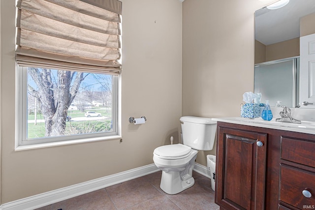 bathroom with tile patterned flooring, vanity, a shower with shower door, and toilet