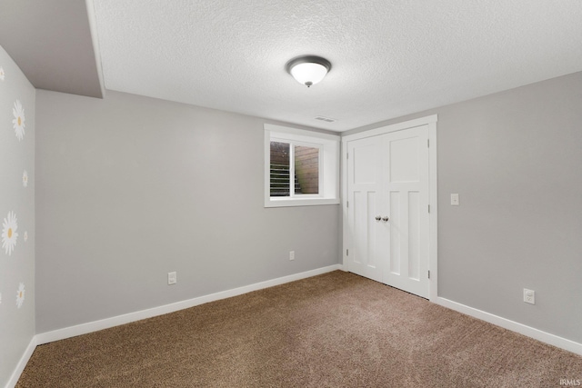 interior space with a closet, a textured ceiling, and carpet flooring