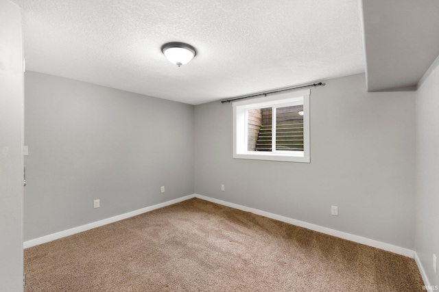 empty room with carpet flooring and a textured ceiling