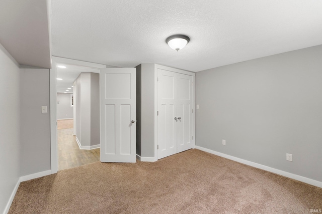 unfurnished bedroom with carpet flooring, a textured ceiling, and a closet