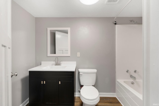 full bathroom featuring shower / bath combination, vanity, wood-type flooring, a textured ceiling, and toilet