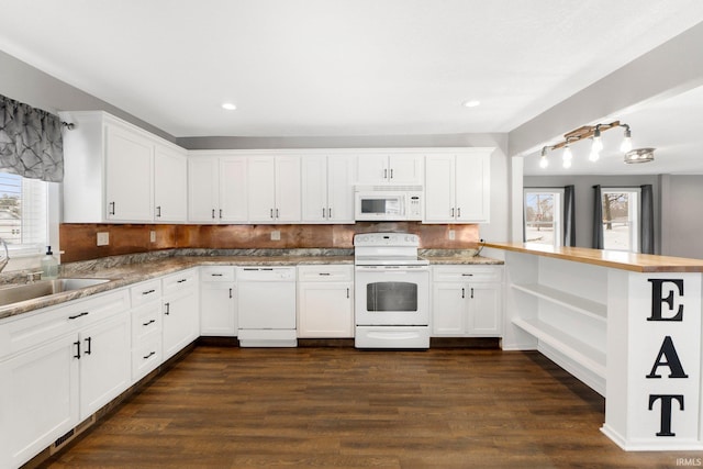 kitchen featuring white cabinetry, white appliances, kitchen peninsula, and sink