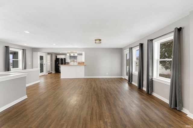 unfurnished living room with dark wood-type flooring