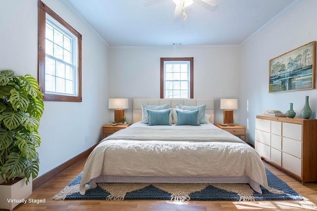 bedroom featuring ceiling fan, ornamental molding, multiple windows, and light wood-type flooring